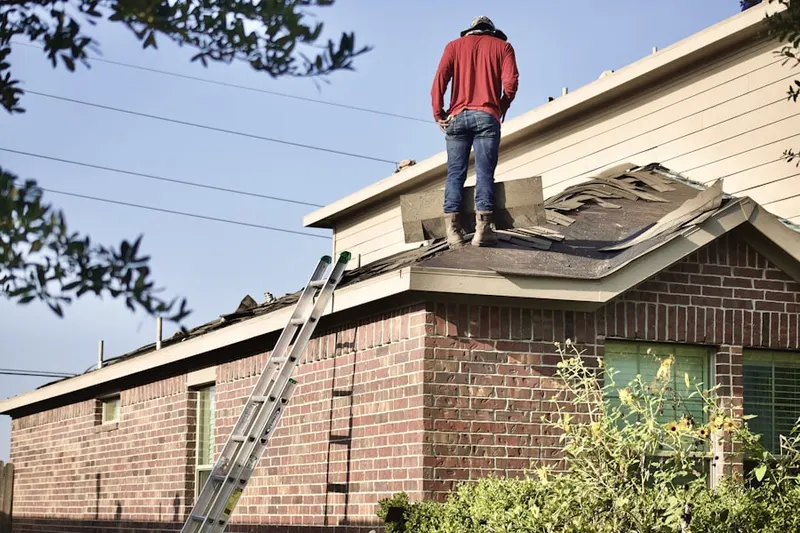 Professional roofer working on a residential roof in Forest Dale